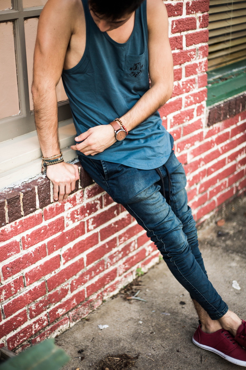 one Person, lifestyles, young Adult, wall, sitting, brick Wall, people, wall - Building Feature, teenager, urban Scene, jeans, real people, standing, blue jeans
