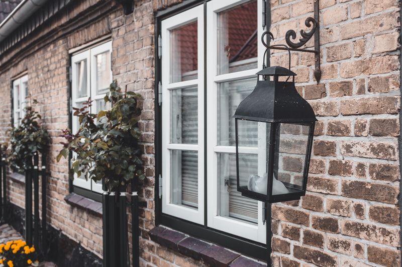 lantern, brown, black, light, architecture, building exterior, windowsill, building, candle, pole, urban, vase, potted plant, residential district, wall
