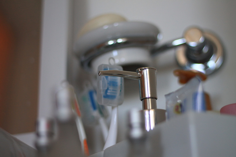selective focus, running water, sink, cleaning, metal, preparation, indoors, domestic bathroom, toothbrush, faucet, domestic room, white, alloy, no people