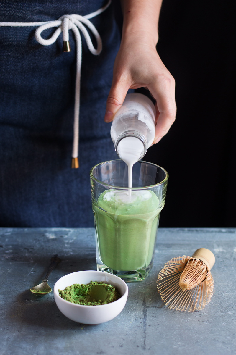 drinking, table, pouring, green, food, drinking glass, real people, matcha latte, lifestyles, human hand, Matcha, finger, household equipment, hand, food and drink