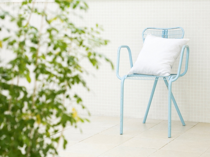 seat, no people, tiled floor, growth, furniture, empty, metal, single object, day, chair, leaf, flooring, armchair, white color, pillow, nature, plant