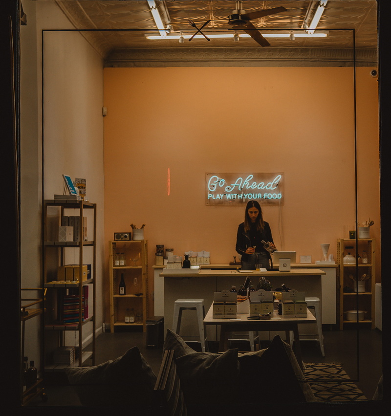 lifestyles, sitting, sign, electric lamp, table, women, chair, behind, food and drink, desk, 2K, adult, front, kitchen, room, indoors, standing, real people