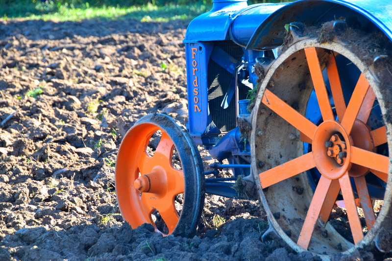arable, orange color, field, mode of transportation, land, old, solid, day, tillage, land vehicle, farm, sunlight, outdoors, tractor, blue, open air museum