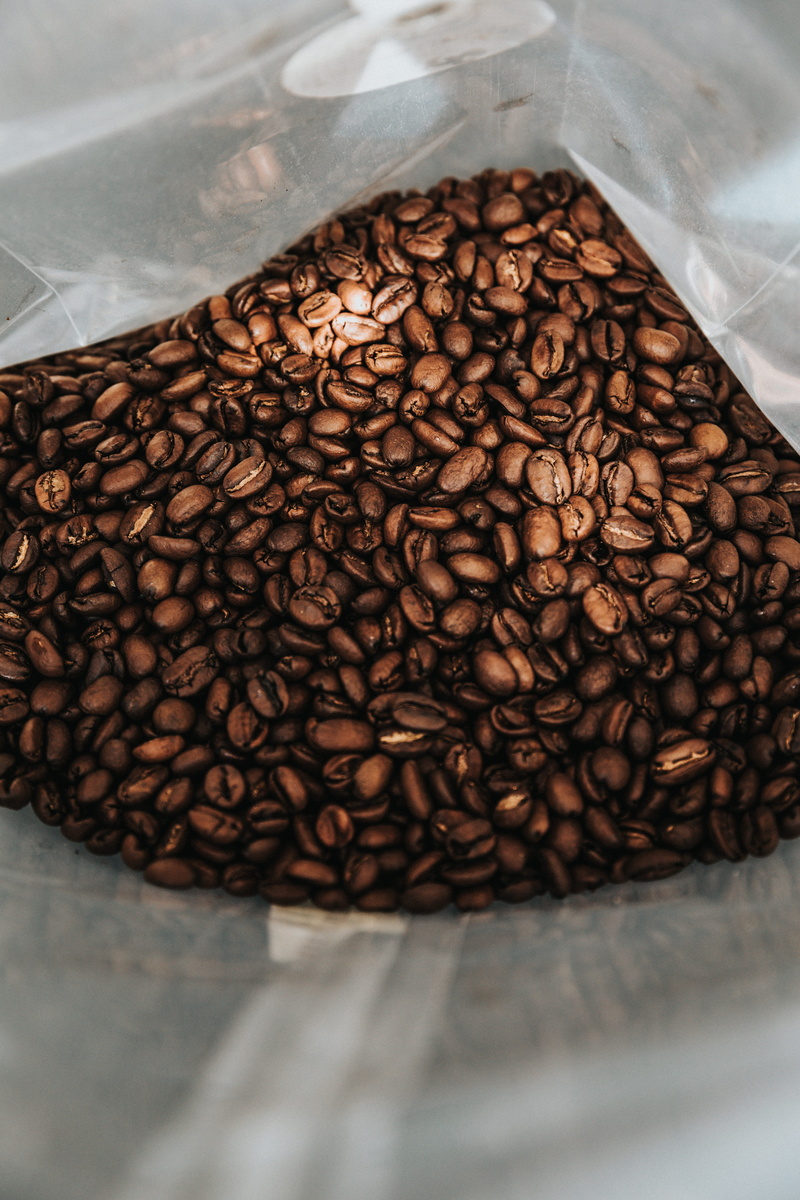no people, coffee roaster, bag, caffeine, indoors, roasted coffee bean, container, coffee, plastic, freshness, table, still life, espresso, abundance, drink