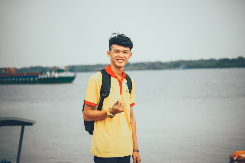 polo, focus on foreground, 5K, yellow, emotion, asian, wearing, child, nautical vessel, portrait, one person, packpack, happiness, body, orange, sea, men