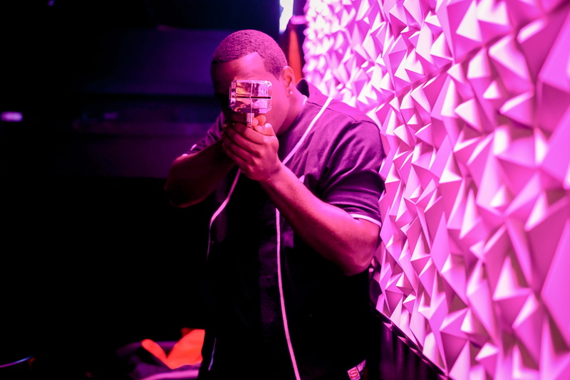 males, pink, working, front view, beside, photography, three quarter length, shallow, dark, holding, occupation, men, man, shaved head, camera, night, indoors