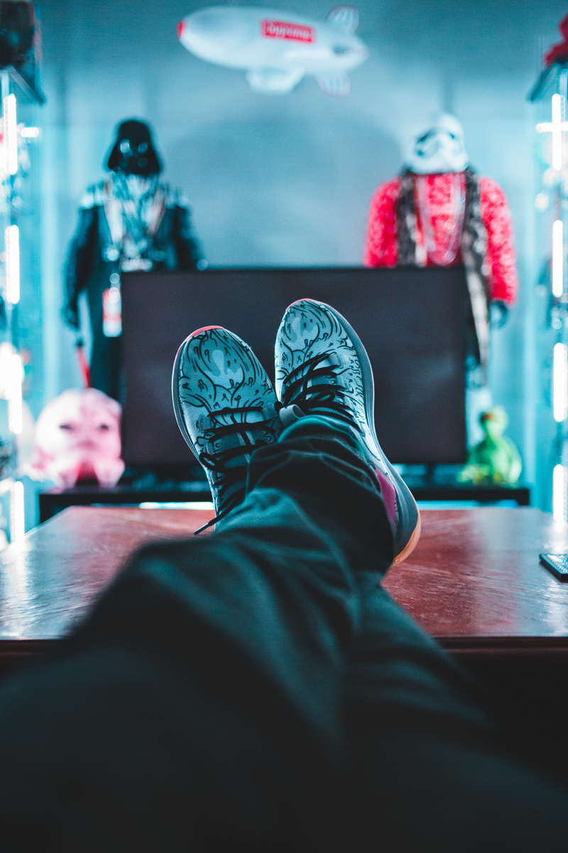 computer, human body part, hardwood, person, shelf, furniture, flooring, floor, desk, men, jeans, relaxation, casual clothing, human foot, personal perspective