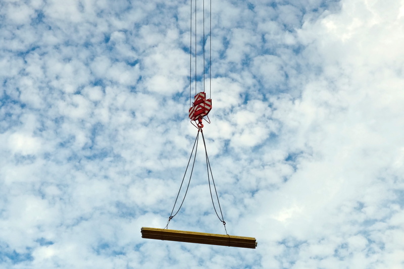 boom, load crane, beauty in nature, lifting crane, rope, construction, red, patriotism, outdoors, crane, clouds, hanging, building, flag, cloud - sky, construction work