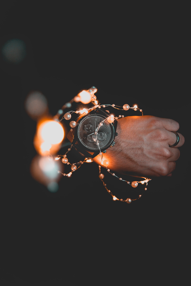 wearing, black background, dark, stopwatch, gold, human finger, human hand, ring, tachometer, black, human body part, wrist, night, hand, men, finger, human