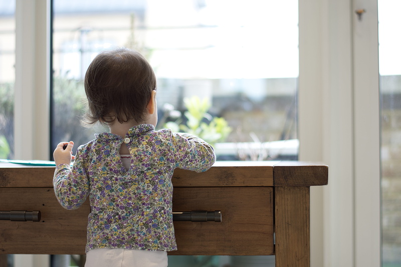 clothing, apparel, standing, hardwood, looking, contemplation, toddler, real people, hairstyle, wood, 5K, china cabinet, closet, floral pattern, leisure activity