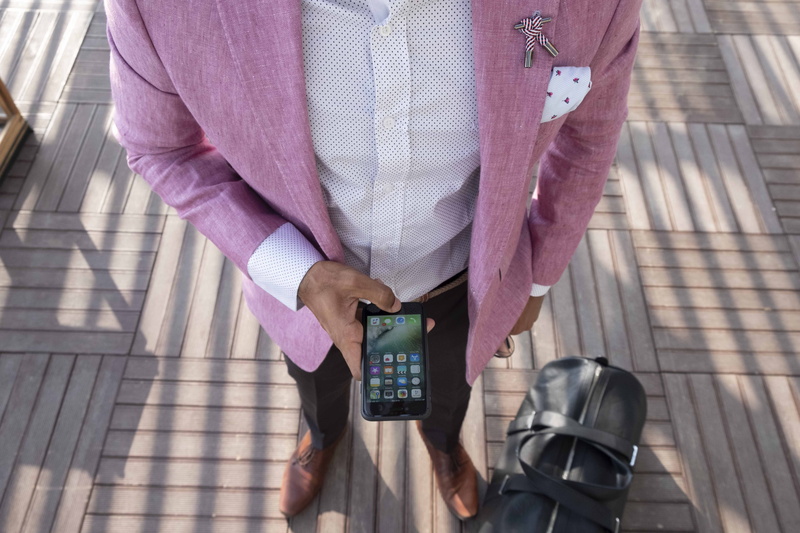travel, real people, smartphone, front view, technology, men, person, hand, lifestyles, outdoors, midsection, women, leisure activity, adult, duffel, pink color