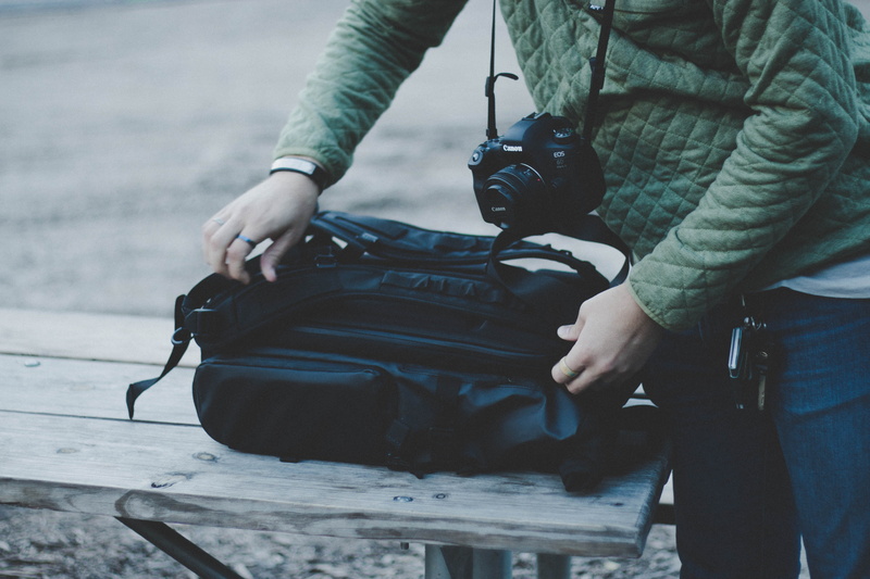 clothing, united states, holding, grey, day, duffel, human hand, warm clothing, one person, real people, lifestyles, outdoors, bag, opening, electronics