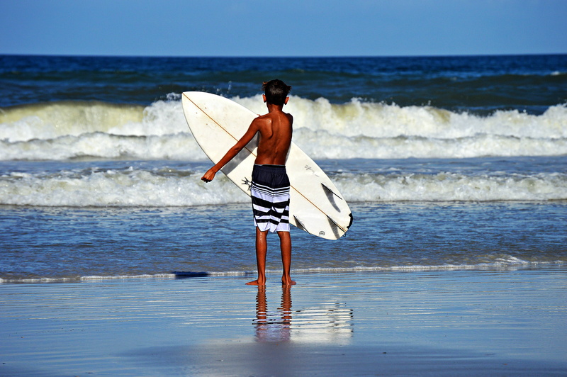 one person, beauty in nature, land, motion, 5K, outdoors, coast, bank, skill, wave, blue, sea, tropical, sun, rear view, spray, landscape, surfer, seascape