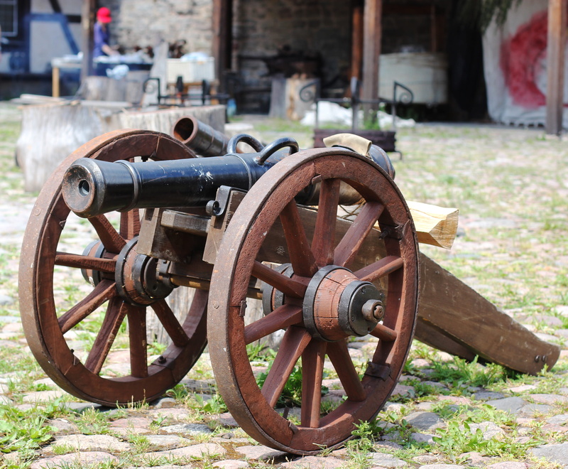 the past, outdoors, focus on foreground, transportation, conflict, day, architecture, old, weapon, kernel, cannon, wagon wheel, metal, wood - material