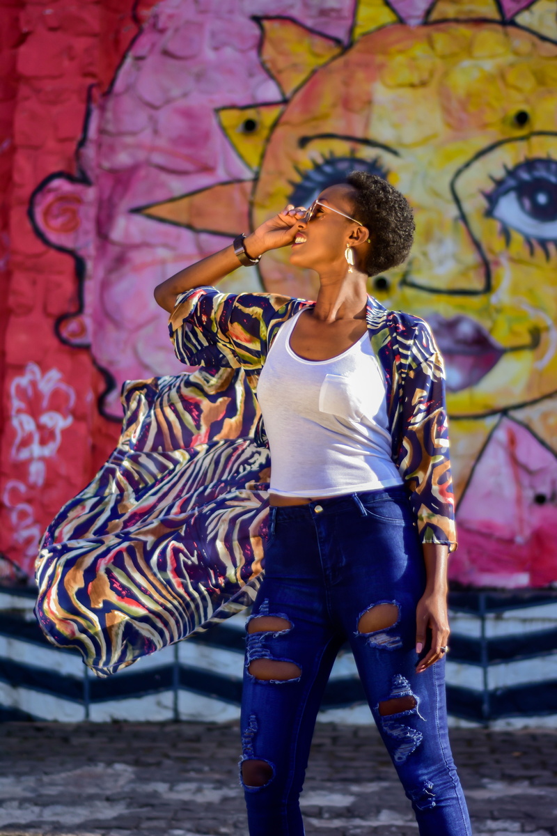 african american, black woman, three quarter length, glasses, woman of color, mural, pattern shirt, 5K, sun, human arm, front view, young women, casual clothing