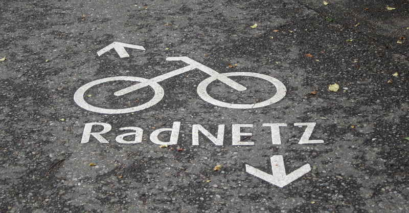 orb web, sign, tar, karl hildebrand, asphalt, transportation, marking, message, cycle path, text, symbol, road sign, wet, ground, city, white color, karl