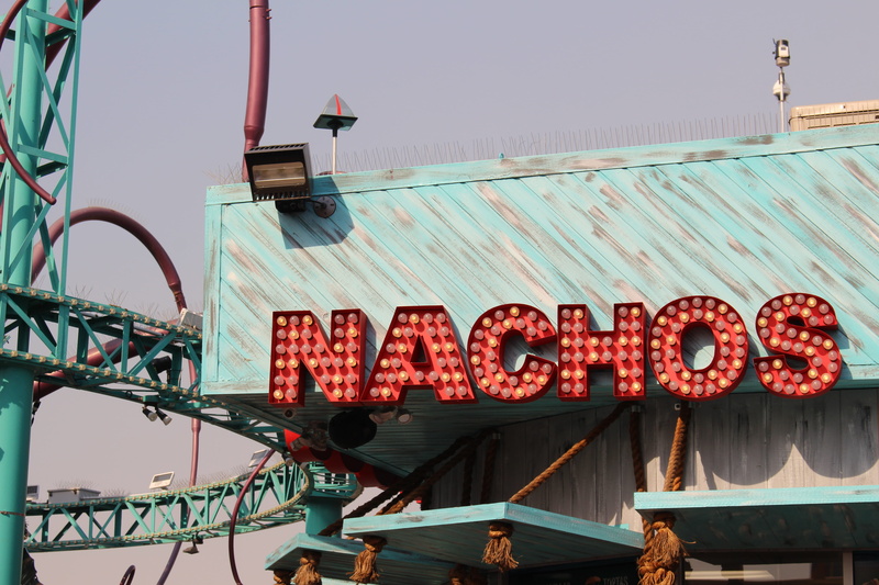 sunlight, neon, lights, text, sign, metal, architecture, amusement park, day, outdoors, nature, nachos, red, large group of objects, transportation, sky