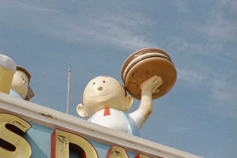 theme park, daytime, belief, nature, outdoors, sculpture, plywood, sky, human representation, burger, cloud - sky, low angle view, holding, figurine, winter