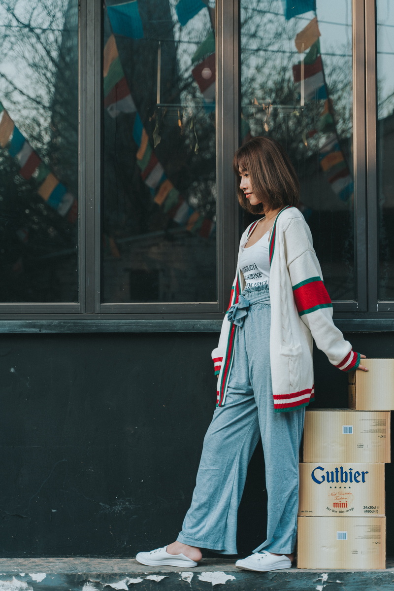 glass - material, apparel, white, shoe, pants, door, person, sleeve, young women, glass, standing, box, building exterior, carton, denim, overcoat, gucci