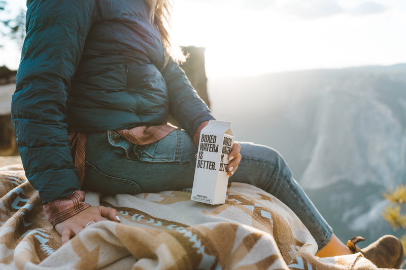relaxation, carton, warm clothing, communication, young adult, jacket, outdoors, holding, 5K, national, adult, yosemite, real people, water, sitting, white
