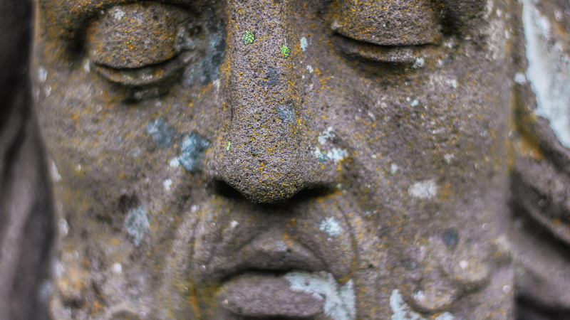 bronze, focus on foreground, deterioration, textured, 5K, human representation, metal, eyes closed, rock, selective focus, figurine, cantal, weathered