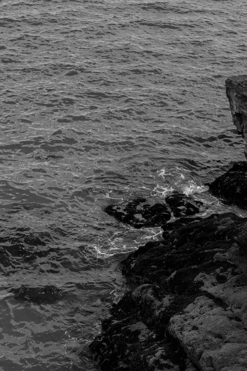 black and white, united kingdom, rock, sea, monochrome, rocky coastline, wave, 5K, beach, solid, land, outdoors, motion, sport, waterfront, rocks, beauty in nature