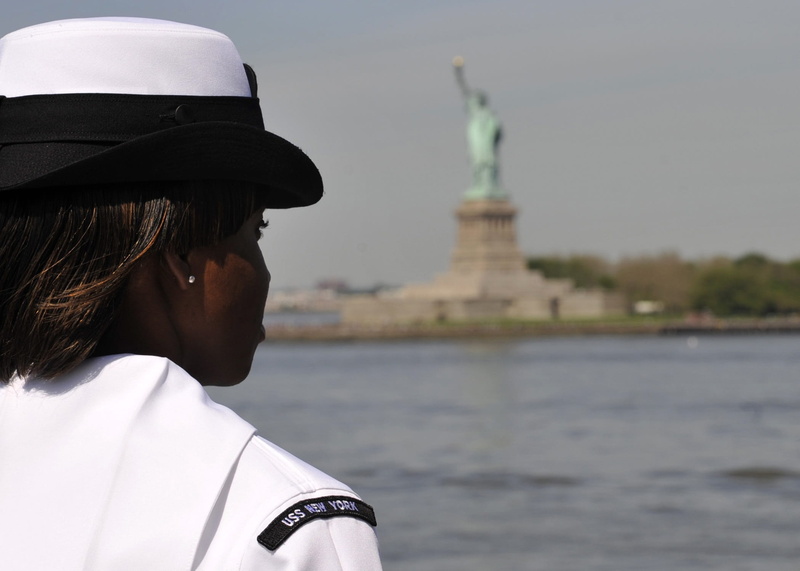 portrait, casual clothing, behind, landmark, rear view, sculpture, statue of liberty, maritime, focus on foreground, outdoors, uniform, real people, water