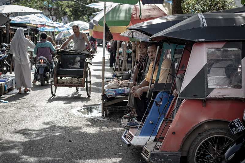 tire, land vehicle, city, incidental people, furniture, person, men, street, real people, nature, architecture, motorcycle, machine, three wheel, sitting