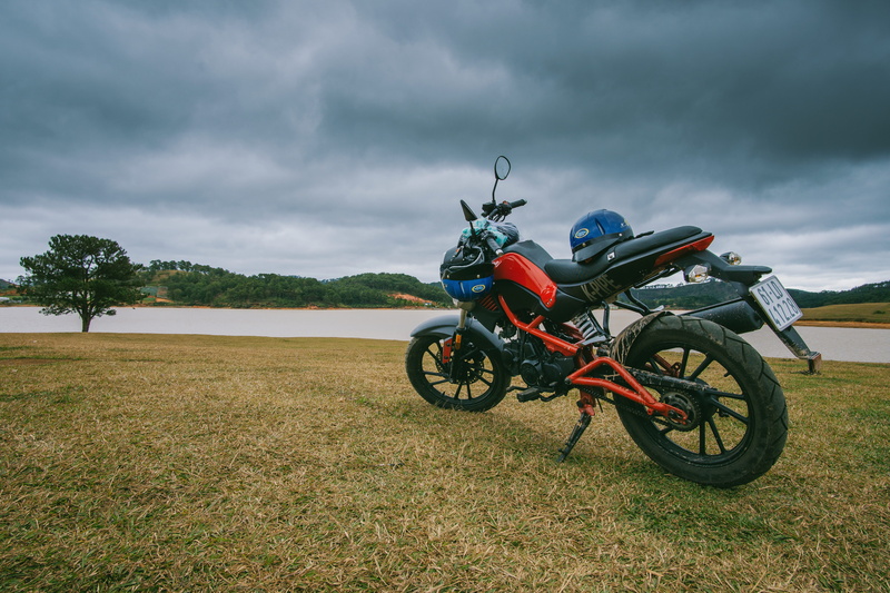 wheel, nature, crash helmet, parked, mode of transportation, red, field, landscape, people, land vehicle, transportation system, land, storm, cloud - sky