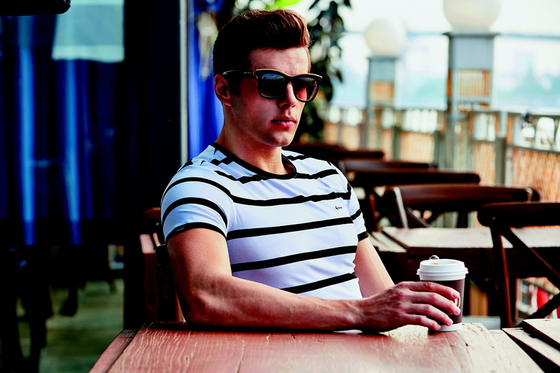 french apple, holding, real people, one person, mug, sunglasses, coffee, leisure activity, outdoors, fashion, fashion business, casual clothing, cafe, young men
