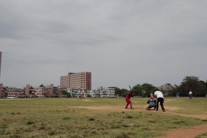 outdoors, day, sky, 2K, people, rear view, playing, two people, landscape, reparto camilo cienfuegos, playball, building, baseball, city, sport, full length