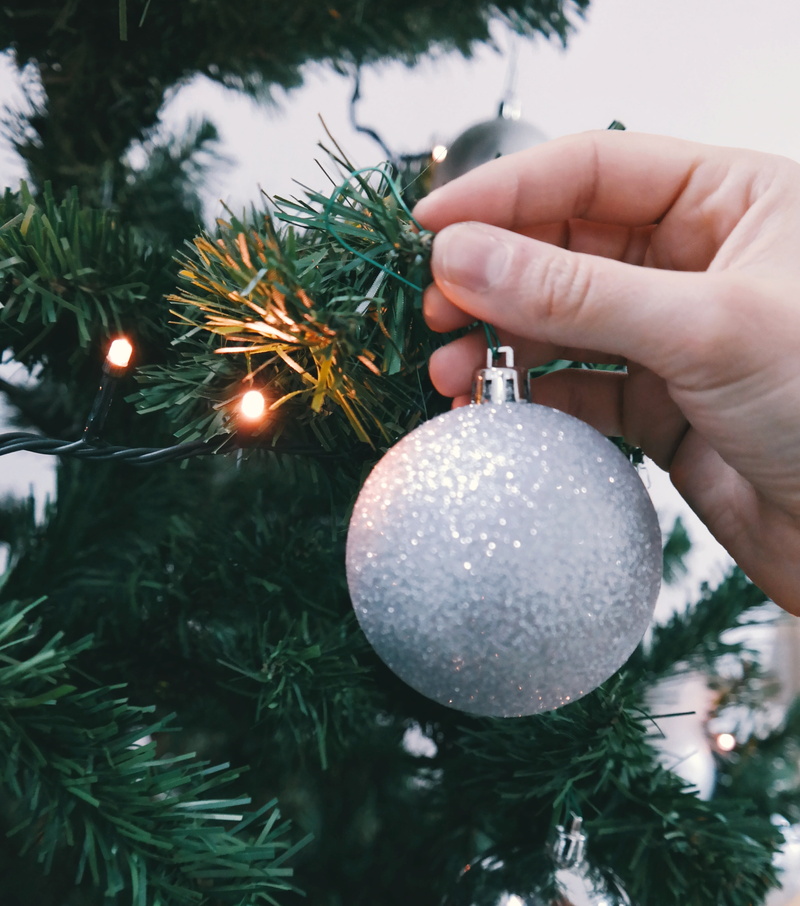 sphere, string, person, celebration, event, baubles, hanging, silver colored, christmas tree, lights, gray, finger, tradition, holiday, human body part