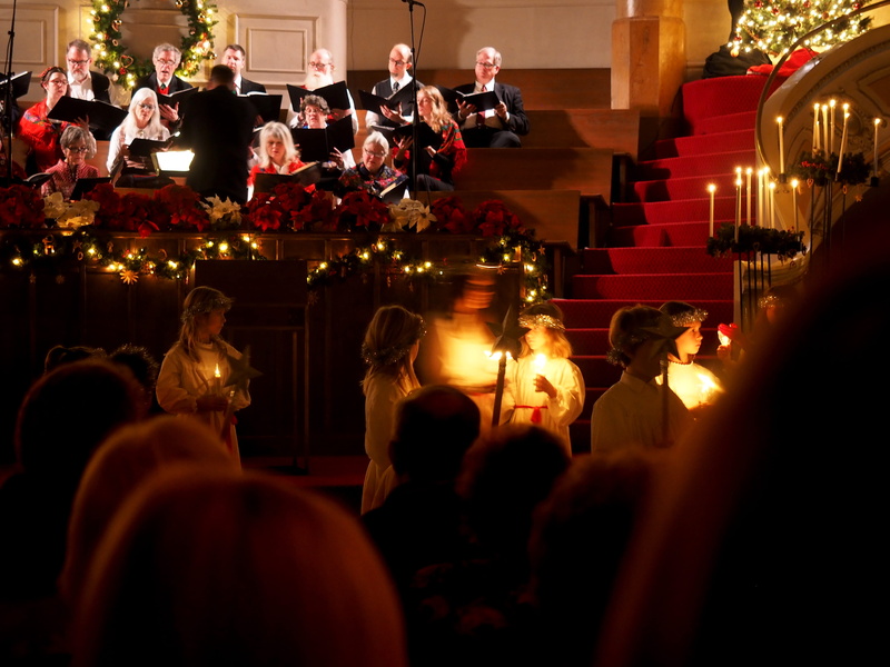 garland, festive, inside, church, large group of people, mature men, males, females, red, concert, candlelight, gold, choir, blur, performance, stage, real people