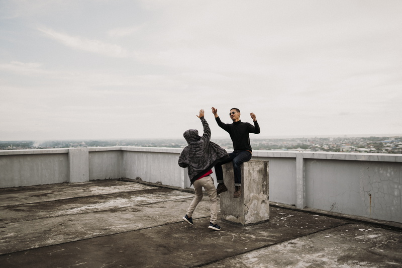 real people, railing, men, cloud - sky, arms raised, happy, leisure activity, two people, friendly, high, young women, sunset, lifestyles, water, daylight