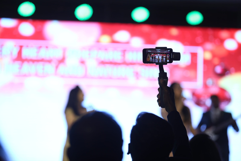 stage light, event, indoors, electronics, rock concert, person, press conference, real people, people, camera, adult, photography, illuminated, video gaming
