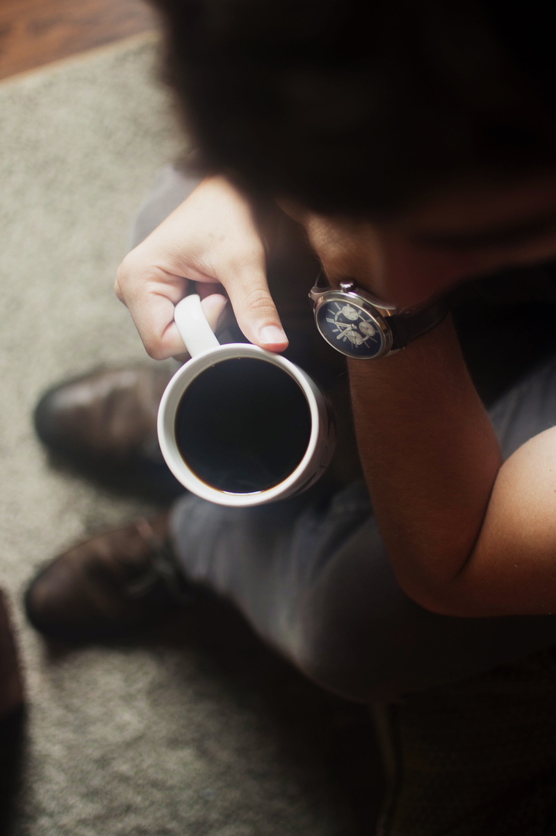 male, lifestyles, food and drink, leisure activity, indoors, relaxed, coffee, man, drinking, watch, couch, finger, black coffee, hand, sitting, drink, from above