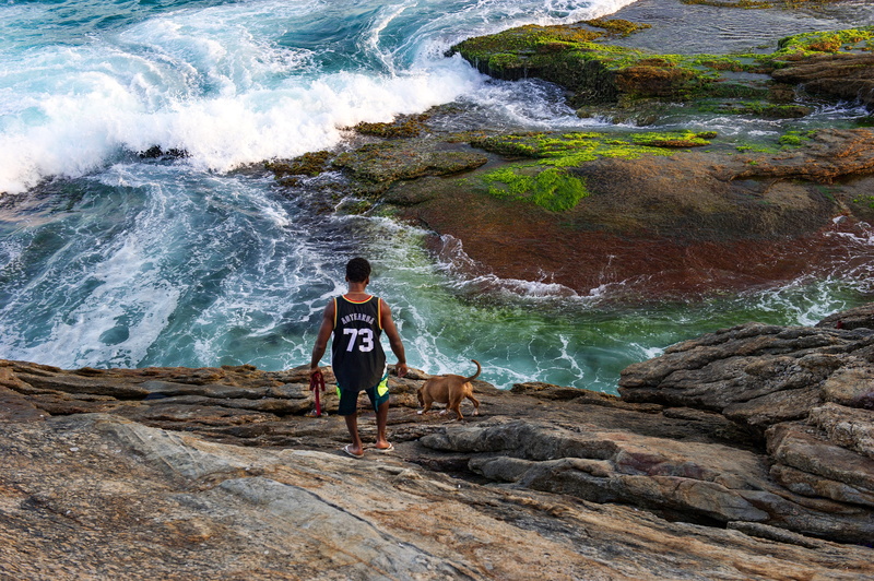 lifestyles, rear view, flowing water, praia do arpoador, standing, outdoors, leisure activity, sunset, rock formation, casual clothing, motion, 4K, full length