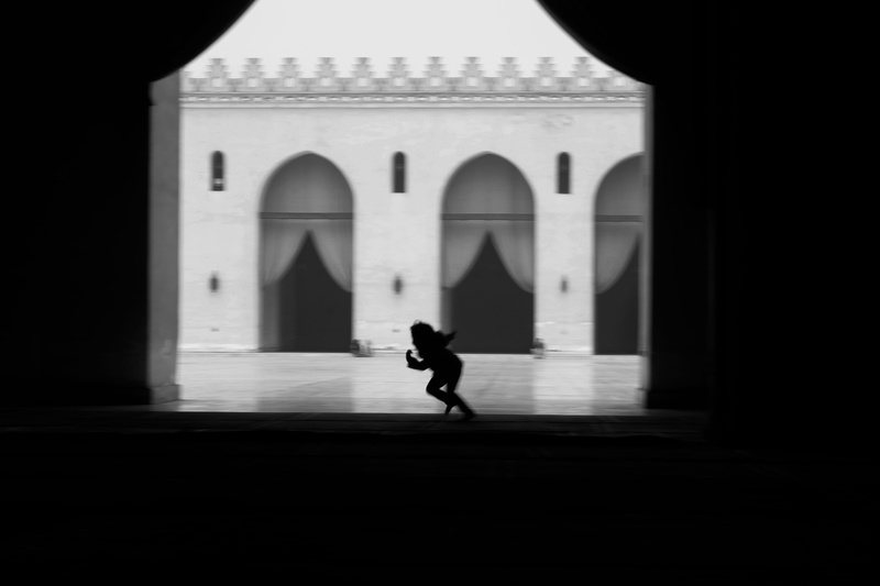 architecture, girl, city, building, lifestyles, mosque, place of worship, men, arch, al hakim mosque, day, built structure, side view, shadow, blackwhite