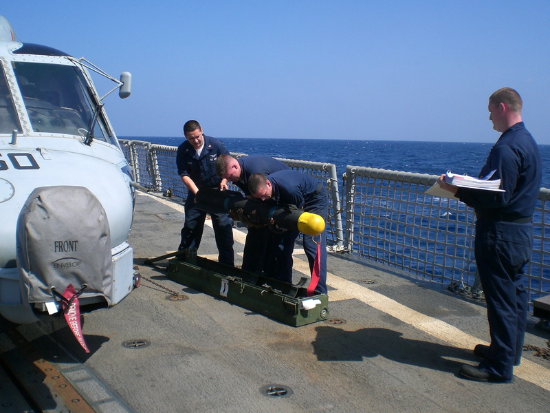 full length, helicopter, standing, uniform, government, ammunition, navy, hellfire, sea, real people, men, water, day, nature, horizon, transportation