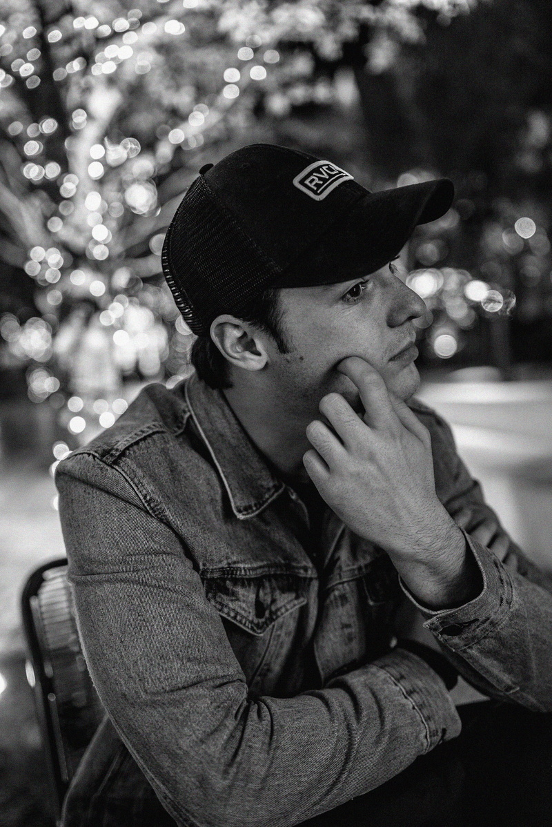denim, real people, bokeh, hat, looking away, portrait, man, front view, looking, focus on foreground, monochrome, leisure activity, jacket, seat, innocence