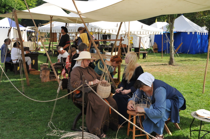 casual clothing, group of people, crowd, field, grass, tent, leisure activity, real people, middle ages, adult, outdoors, sitting, nature, medieval market