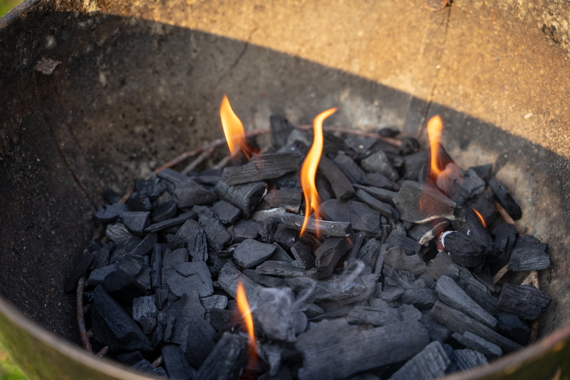 camping, fireplace, wood - material, bbq, heat, day, bratwurst, charcoal, black, outdoors, no people, high angle view, grill, barbecue, eat, orange color