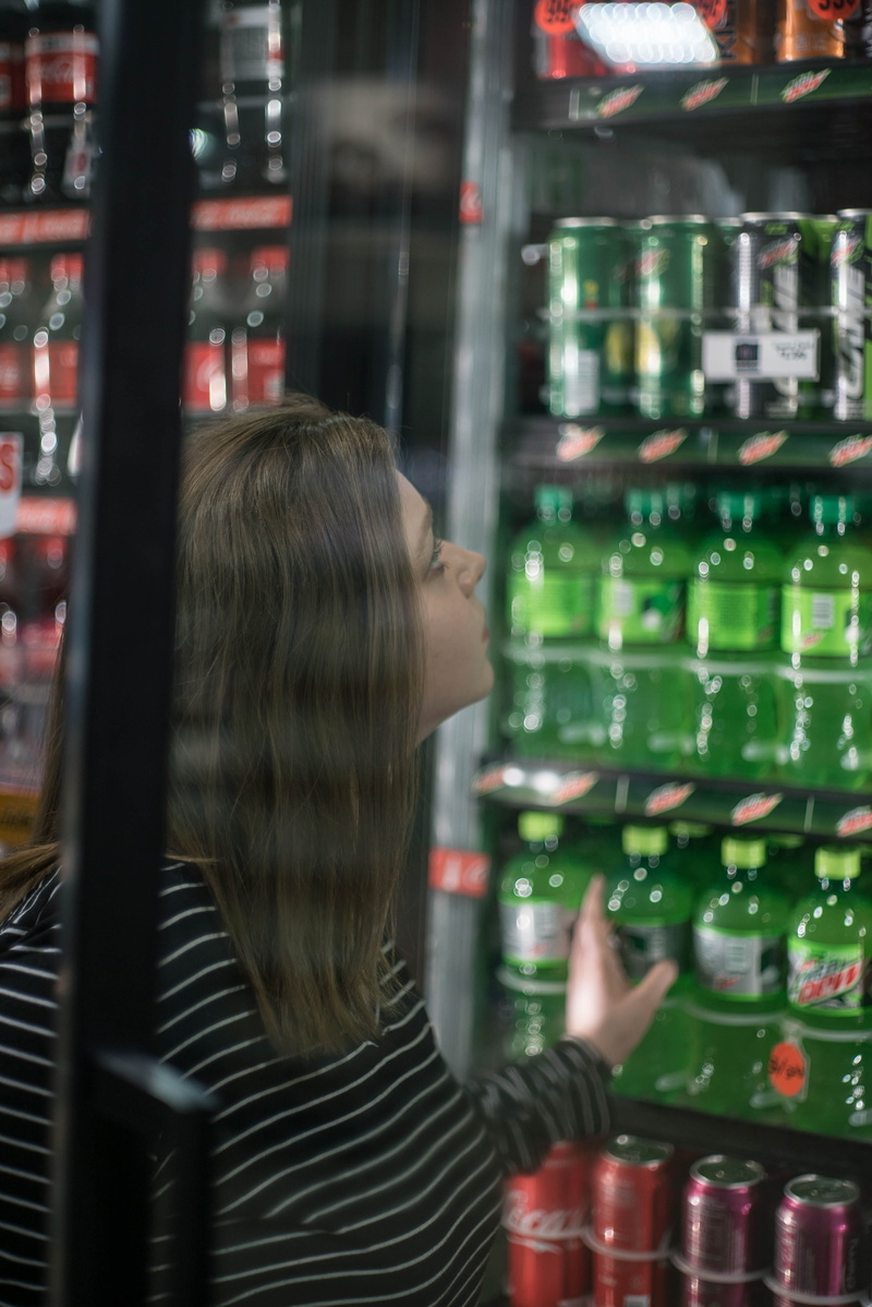 food and drink, long hair, vending machine, machine, drink, mountain dew, bottle, window, hair, real people, convenience store, sphere, hairstyle, human