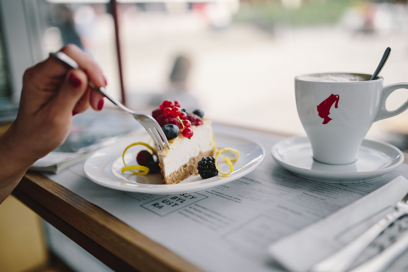 hand, dessert, indoor, cup, mug, woman, cafe, enjoying, cheese cake, cafeteria, human hand, drink, saucer, restaurant, time, food and drink, kitchen utensil
