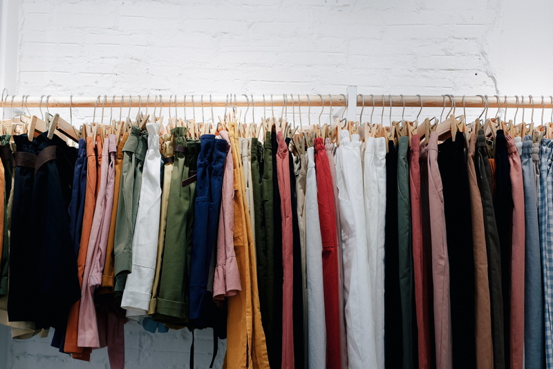 in a row, coathanger, multi colored, order, clothes rack, shopping, wall, store, garment, arrangement, sale, clothing, textile, no people, clothes, abundance