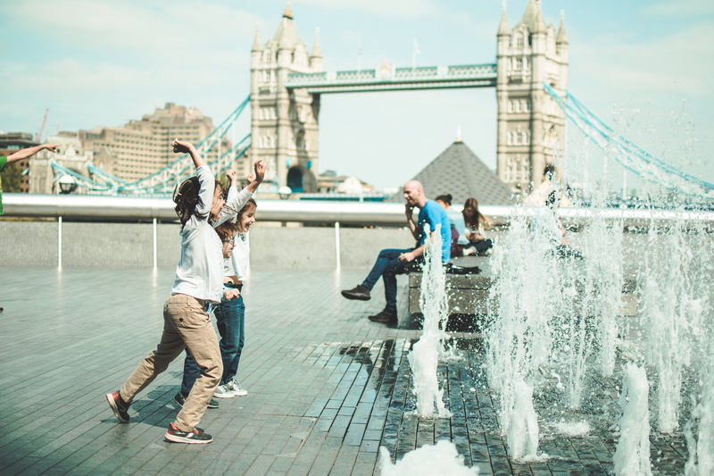 person, trip, tower bridge, innocence, building exterior, water, children playing, street, fountain, sky, real people, united kingdom, near, kids playing