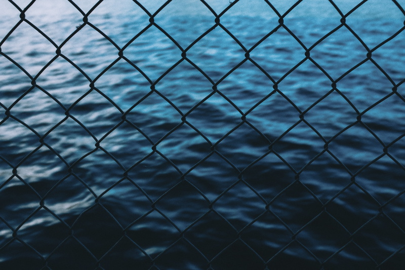 no People, chainlink fence, grid, fence, blue, boundary, full frame, metal, day, focus on foreground, outdoors, water, sea, 4K, gray, backgrounds, barrier