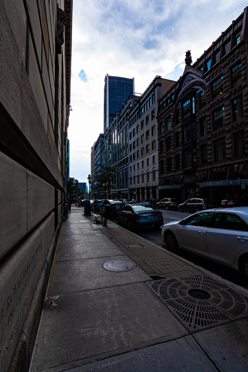 transportation, land vehicle, city street, canada, street, nature, motor vehicle, day, incidental people, city, montréal, skyscraper, built structure, mode of transportation