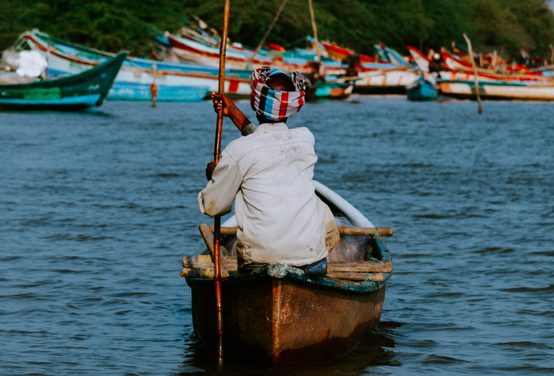 person, middle, vessel, barge, colors, real people, sitting, apparel, day, sea, rear view, outdoors, human, watercraft, river, focus on foreground, boat