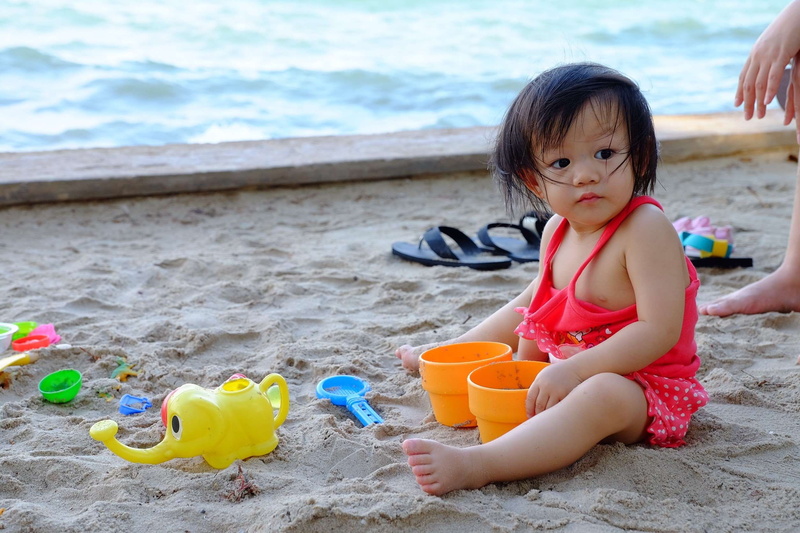 land, 1080P, sand pail and shovel, day, water, children, beach, sitting, full length, outdoors, innocence, one person, child, lifestyles, females, sand